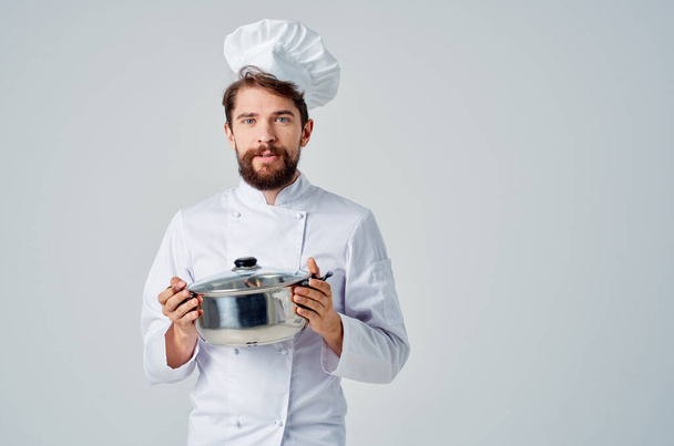 Cheerful chef masculino com uma panela em suas mãos fornecendo trabalho de serviço em um restaurante - Foto, Imagem