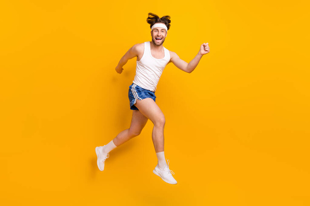 Full length body size view of attractive cheerful guy jumping running activity isolated over bright yellow color background - Photo, Image