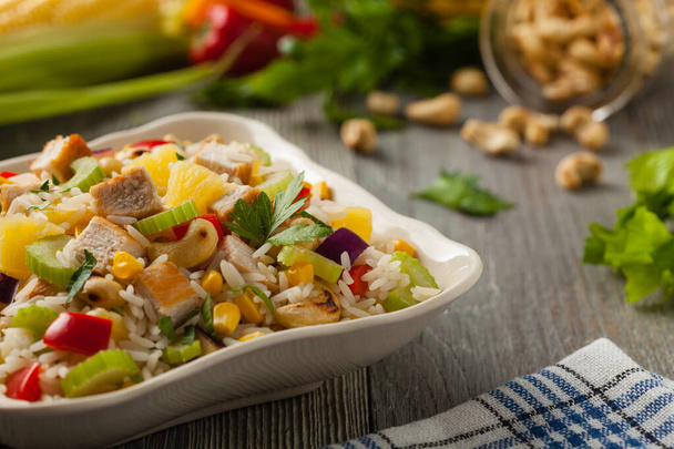 Salad with rice, chicken, peanuts and vegetables. Front view.  - Foto, afbeelding