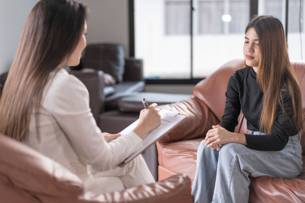 Ruh sağlığı sorunu olan Asyalı genç bir kadın danışmanlık ve zihinsel terapi için psikologla görüşüyor. Psikoloji ve zihinsel terapi kavramı - Fotoğraf, Görsel