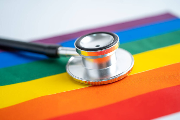 Stetoscopio nero su sfondo bandiera arcobaleno, simbolo del mese dell'orgoglio LGBT celebrare annuale nel mese di giugno sociale, simbolo di gay, lesbiche, bisessuali, transgender, diritti umani e pace. - Foto, immagini