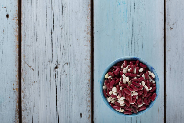 Haricots rouges - source de protéines pour la nourriture végétarienne dans un bol sur fond de bois bleu - Photo, image