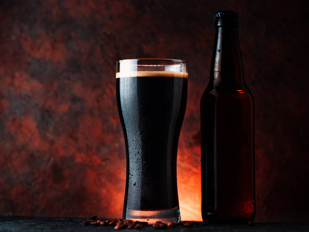 Un verre de bière porteuse sombre avec du café ajouté. Un verre sur un fond brun rouillé avec un contre-jour - Photo, image