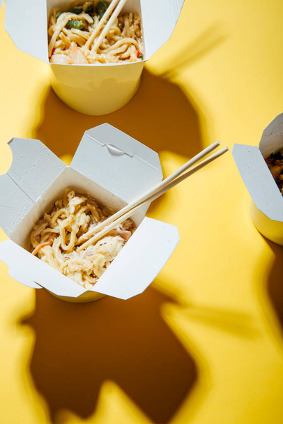 крупним планом вид смачної азіатської їжі в паперових коробках
 - Фото, зображення