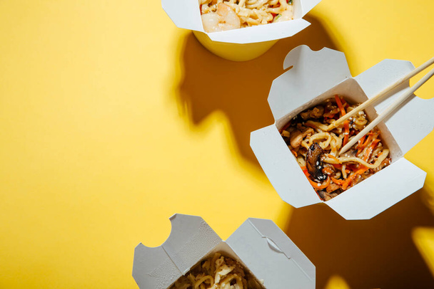 закрыть обзор вкусной азиатской еды в бумажных коробках - Фото, изображение