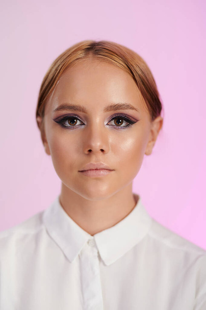 Nahaufnahme Porträt einer jungen Frau mit ruhigem Make-up isoliert auf rosa Studiohintergrund - Foto, Bild