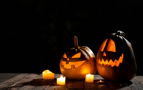 Scary Halloween background with two glowing pumpkin heads and candles. - Foto, imagen