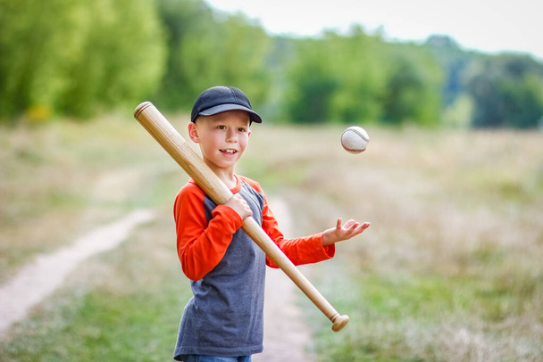 Happy child with baseball bat on nature concept in park - Фото, изображение