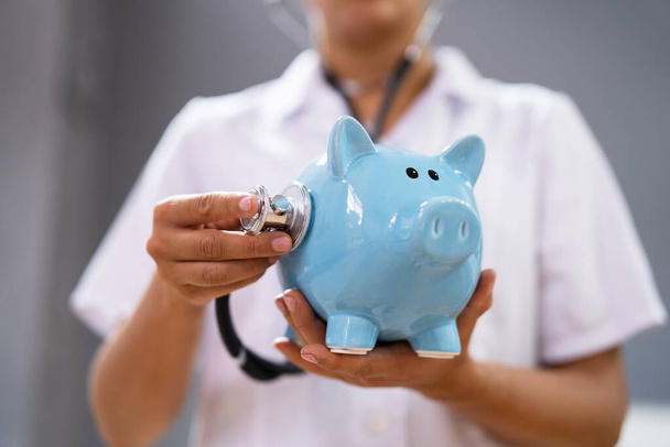 Doctor Health Checking Piggy Bank With Money Inside - Zdjęcie, obraz