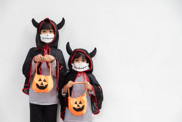 Happy sibling girls at the halloween party. children wearing costumes halloweens. concept of children ready for a party.  - Photo, Image