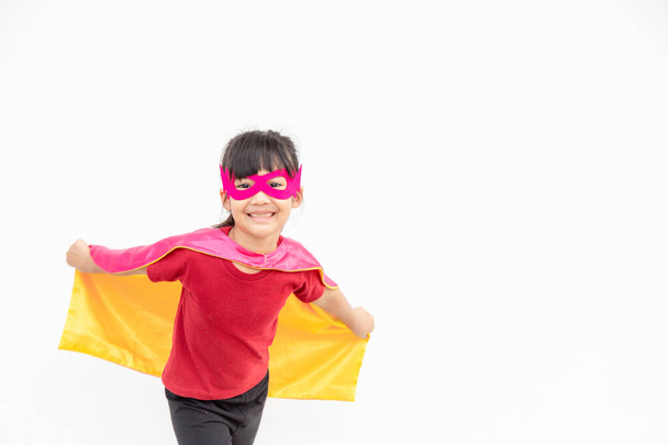 Забавная маленькая девочка играет в супергероя на белом фоне. концепция супергероя. - Фото, изображение