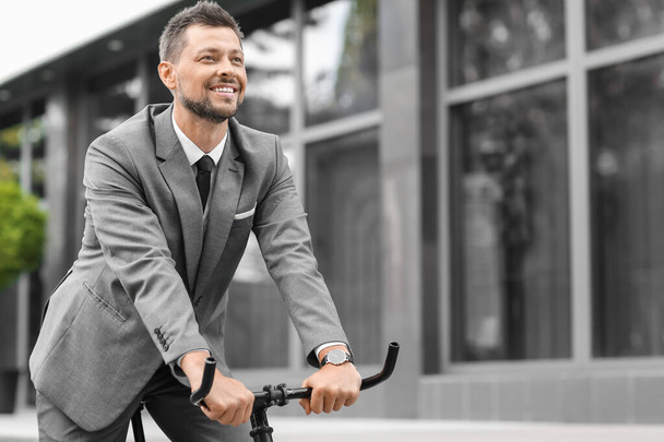Бизнесмен собирается работать на велосипеде на городской улице - Фото, изображение