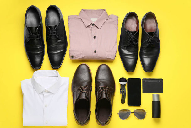 Стильний чоловічий одяг, мобільний телефон, смарт-годинник та аксесуари на кольоровому фоні
 - Фото, зображення