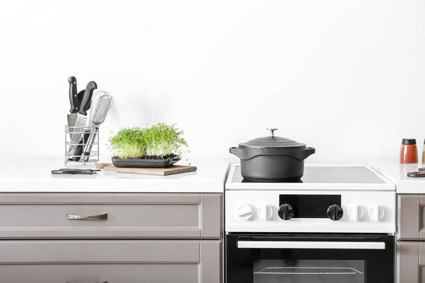 Comptoir de cuisine moderne avec cuisinière électrique près du mur de lumière - Photo, image