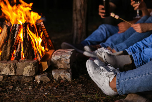Ώριμοι άνθρωποι κοντά σε φωτιά σε μπάρμπεκιου το βράδυ του καλοκαιριού, closeup - Φωτογραφία, εικόνα