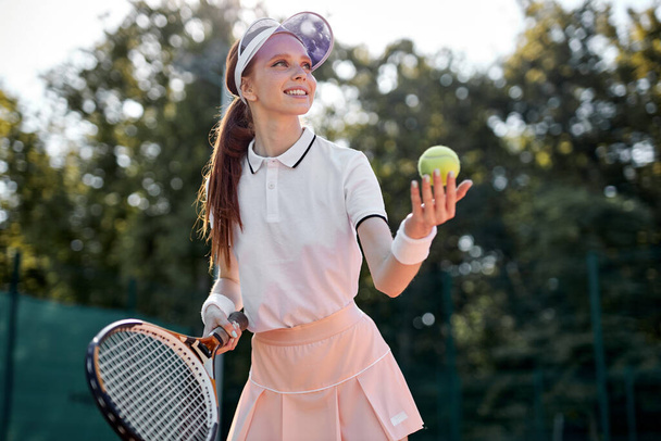 Portrait Of Positive Caucasian Tennis Player On Hardcourt During Game At Summer Day - Photo, Image