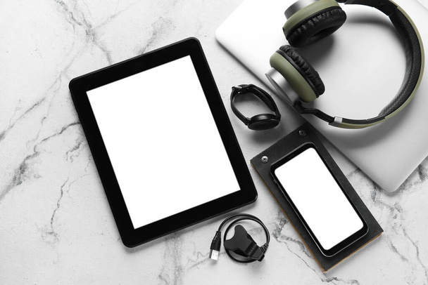 Different modern devices and notebook on light background - Photo, Image