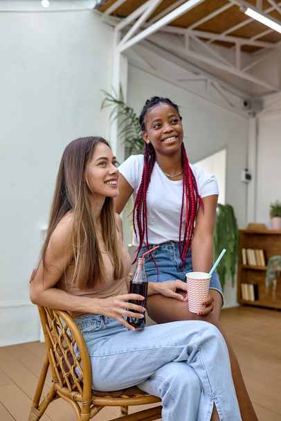 Two happy diverse girlfriends having fun at barbecue party outdoor in house backyard - Photo, image