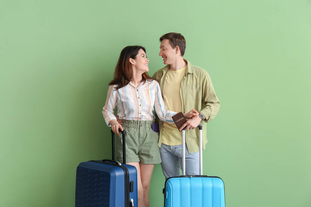 Пара туристов с багажом на цветном фоне - Фото, изображение