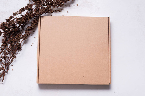 Brown carton cardboard box decorated with dried branch, mock up - Φωτογραφία, εικόνα