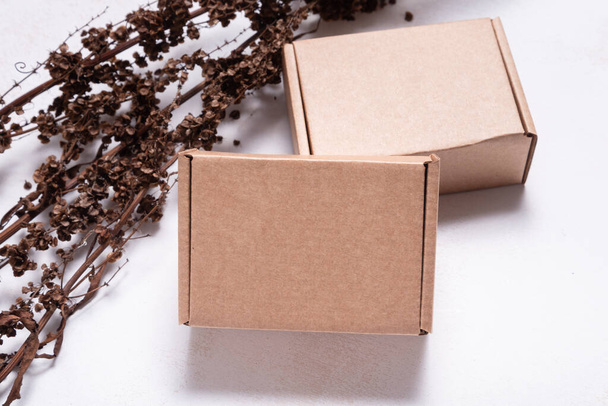 Brown carton cardboard box decorated with dried branch, mock up - Fotó, kép