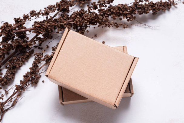 Brown carton cardboard box decorated with dried branch, mock up - Φωτογραφία, εικόνα