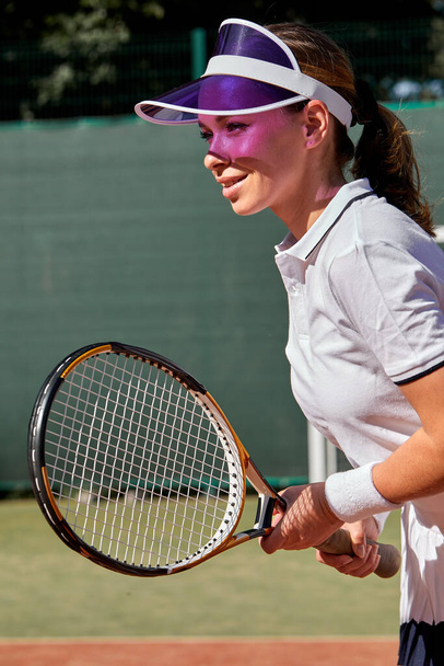 Female tennis player playing game on outdoor court. Athlete caucasian woman with racket - Foto, afbeelding