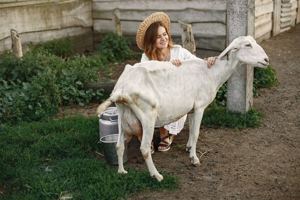 Putdoor portrait of young happy woman with goat - Foto, Imagem