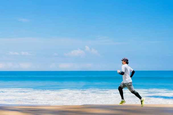 hombre corriendo en la playa Hay una hermosa vista al mar. corriendo en la playa - Foto, imagen