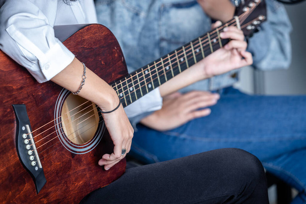 Close up Two women fingers holding mediator with a Guitar recording a song in recording studio - 写真・画像