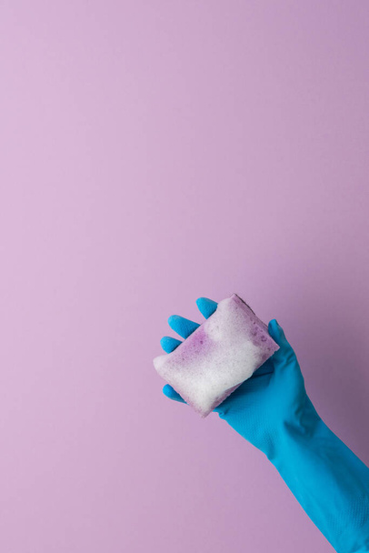 Ręka w gumowych rękawiczkach trzyma gąbkę do zmywania naczyń - Zdjęcie, obraz