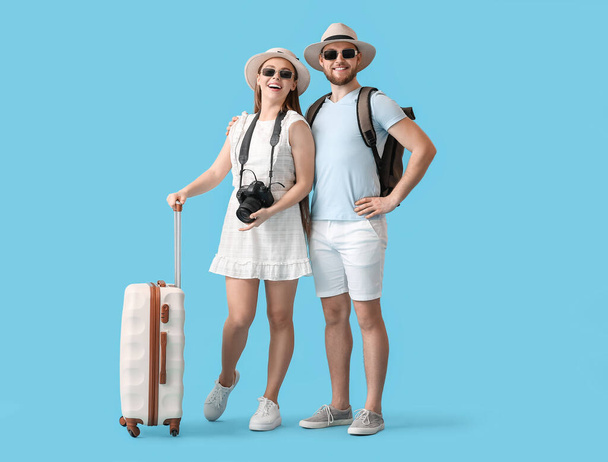 Couple of tourists on color background - Foto, imagen