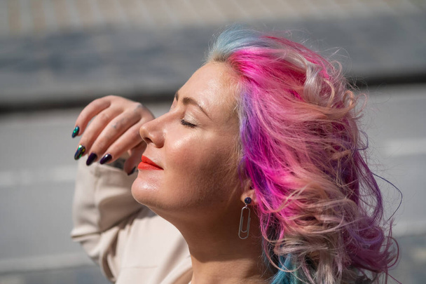 Çok renkli saçlı, kıvırcık beyaz bir kadının yakın plan portresi. Saç stilleri için model - Fotoğraf, Görsel