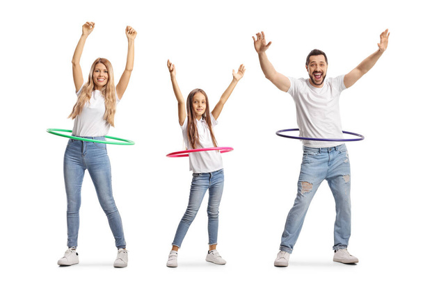 Family of a mother, father and daughter spinning hula hoops isolated on white background - Valokuva, kuva