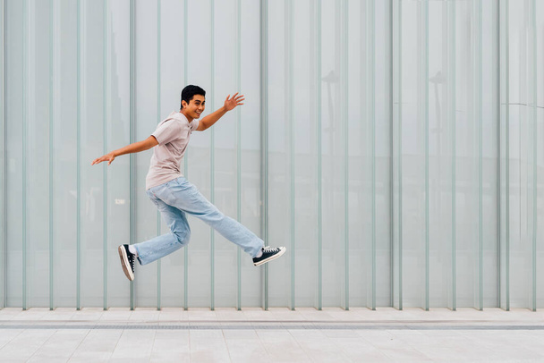 Fiatal ázsiai férfi szabadtéri jumping ünnepli siker érzés szabad  - Fotó, kép