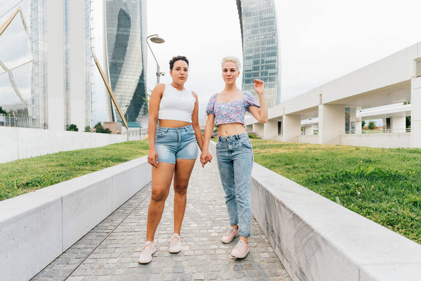 Couple of young multiethnic women outdoor holding hands having fun together - Zdjęcie, obraz