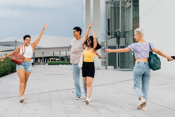 Gruppe junger muliethnic Leute Freunde tanzen draußen an windigem Tag lächelnd Spaß haben - Foto, Bild