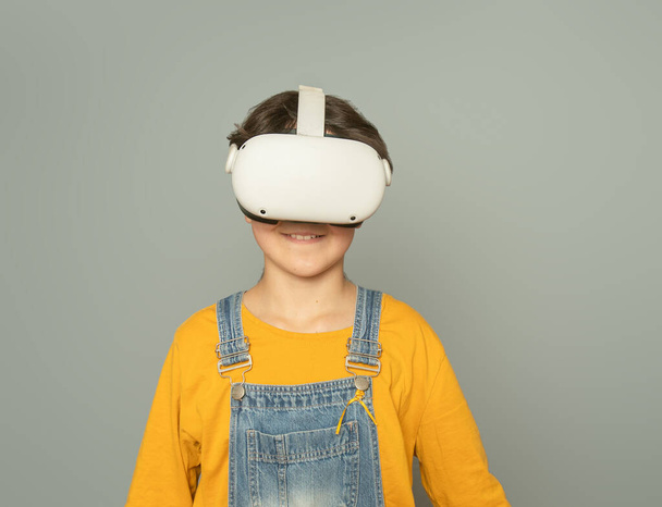 灰色の背景、デジタル技術の概念、革新的な技術で仮想現実を再生する子供の女の子 - 写真・画像