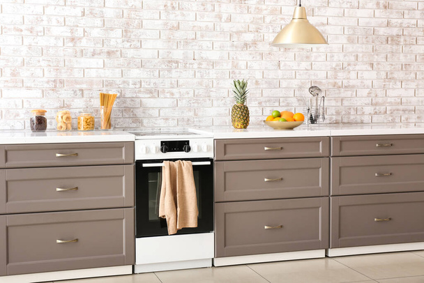 Modern furniture with electric oven near brick wall - Photo, Image