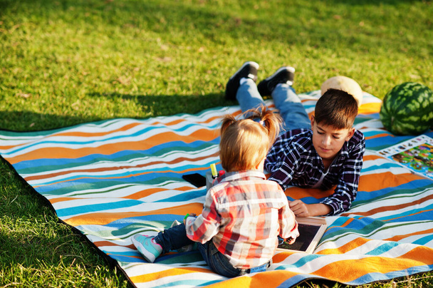 Family spending time together. Brother with sister painting outdoor in picnic blanket. - Photo, Image