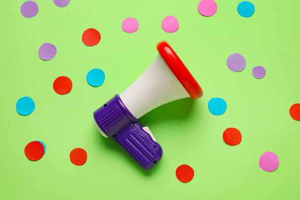 Toy megaphone and paper circles on color background - Photo, Image
