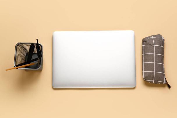 Κομψή κασετίνα μολυβιού, laptop και χαρτικά σε έγχρωμο φόντο - Φωτογραφία, εικόνα