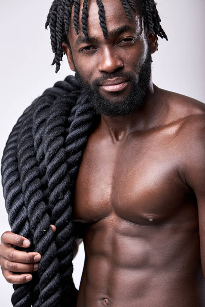 young sexy active black man going to train with battle ropes, keeping fit, isolated - Foto, Bild
