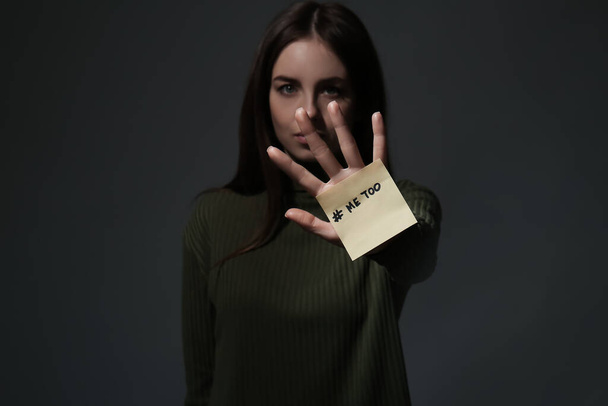 Uwaga papier z hashtag MeToo na rękę młodej kobiety na ciemnym tle - Zdjęcie, obraz