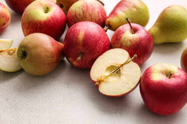 Ripe pears and apples on light background - Фото, зображення