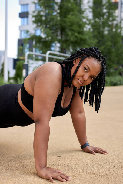 Beautiful young fat african woman wearing black sportswear working out outdoors - Photo, Image