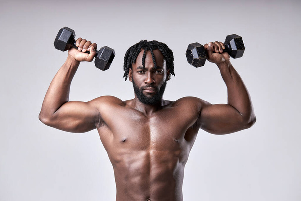Handsome strong young guy bodybuilder of african appearance doing exercises - Foto, Imagen