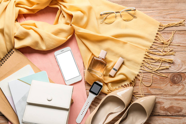 Női ruhák, stílusos kiegészítők és okostelefon fa háttér - Fotó, kép