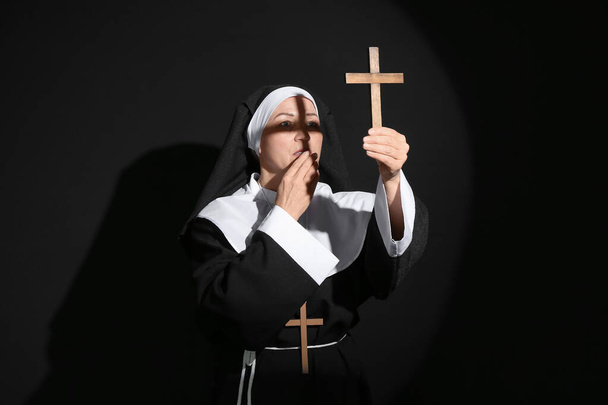 Mature nun with cross on dark background - Foto, Imagem