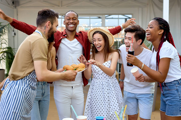 Young friends having party in the evening, house patio, eating burgers, laughing - Photo, Image